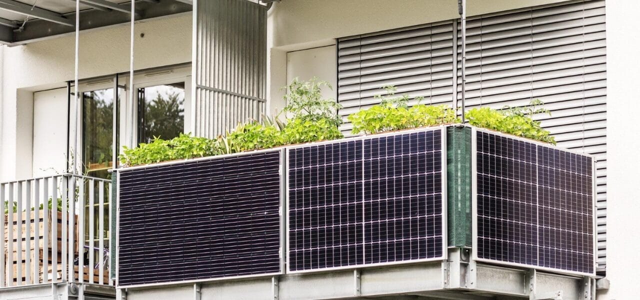 Balkonkraftwerk mit zwei Solarpaneelen an einem modernen Balkon mit Pflanzen.